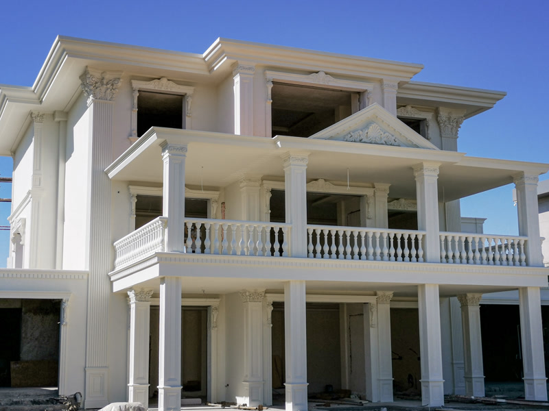 Binanın beyaz dış duvarlarında yer alan oymalı poliüretan pilaster sütun detayları ve şık pencere çerçeveleri.