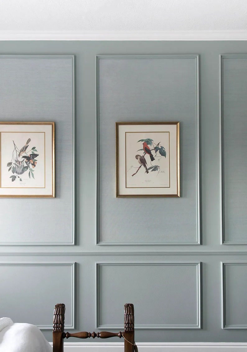 Adaçayı yeşili duvara uygulanan, içinde altın sarısı yaldızlı tablolar bulunan P85016 ve P85403 klasik wainscoting panelleri.