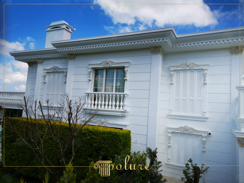 Klasik tarzdaki villanın beyaz poliüretan pilaster sütun, pencere sövesi, taç ve korkuluklarla tasarlanmış dış cephesi.