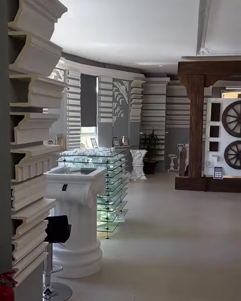 Dekoratif sütunlar ve ahşap görünümlü geçişle showroomun genel görünümü