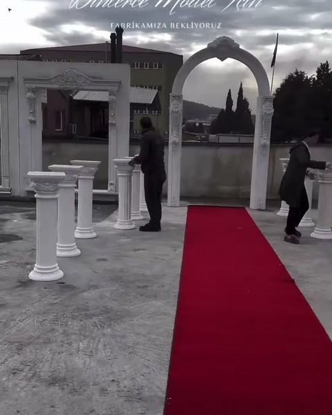 Kırmızı halı, sütunlu geçiş ve kemerli giriş birlikte görülüyor
