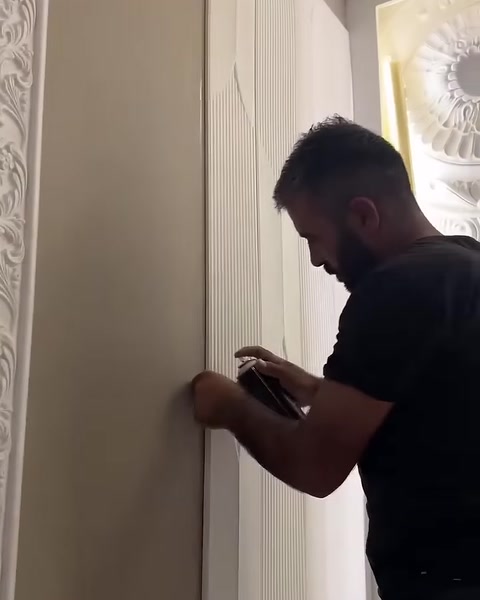 Usta, dekoratif panelin yan kenarında sabitleme işlemi gerçekleştiriyor