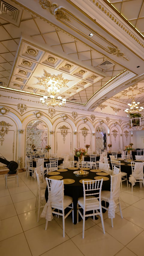 Süslemeli tavan panelleri altında hazırlanan yuvarlak davet masaları