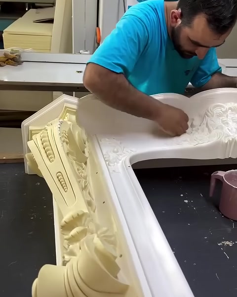 Usta, şömine üstlüğünün merkezindeki kabartmaları dikkatle işliyor.