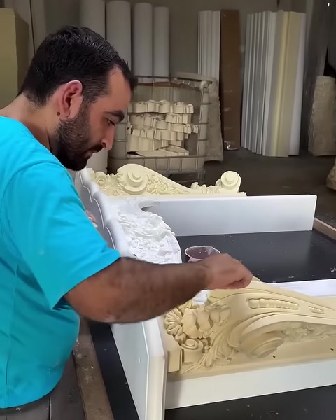 Usta, kıvrımlı şömine üstlüğünün kenarında son kontrolleri yapıyor.