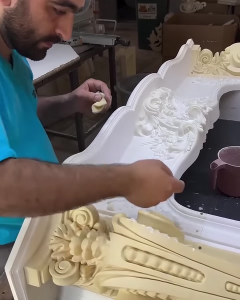 Usta, dekoratif şömine çerçevesine küçük bir parça yerleştiriyor.
