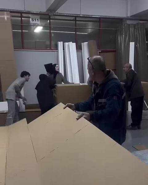 Çalışan ambalaj kutusu için büyük karton levhayı hazırlıyor