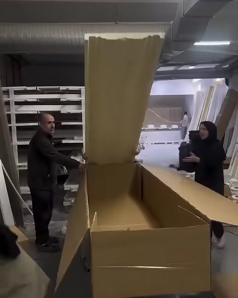 Kesilmiş karton parça uzun ürün kutusunun üzerine kaldırılıyor