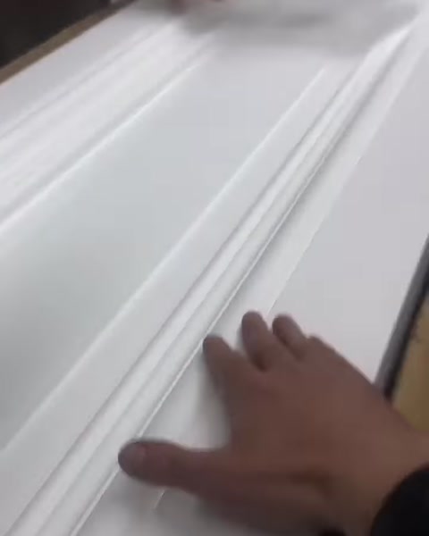 Kademeli yüzeye sahip beyaz dekoratif çıta detayı inceleniyor