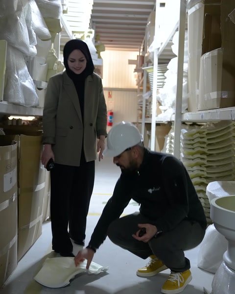 Görevli, depo zeminindeki dekoratif parçayı eğilerek kontrol ediyor.