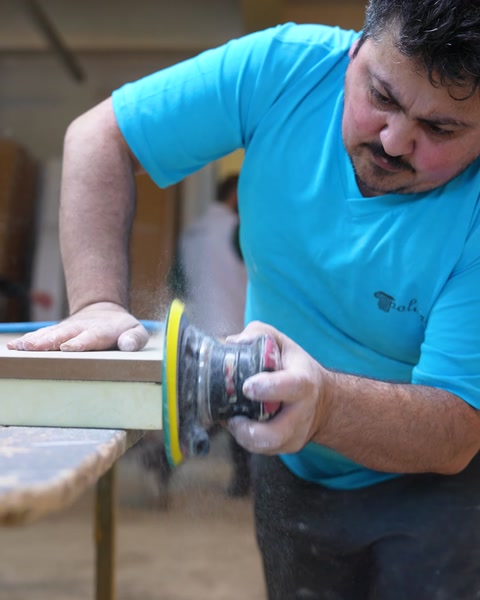 Masa tablasının kenarları zımpara makinesiyle pürüzsüz hale getiriliyor.