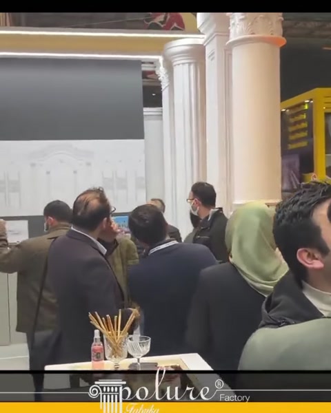 İşlemeli başlıklara sahip klasik sütunlar stand girişini çevreliyor