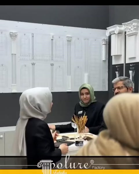 Duvar panosundaki uzun dekoratif profiller görüşme alanına eşlik ediyor