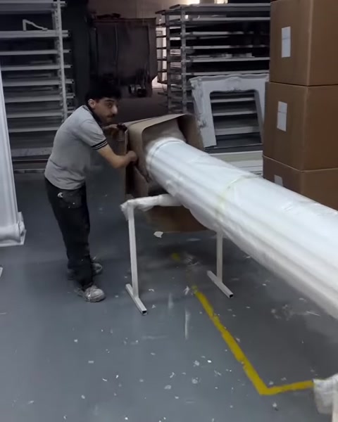 Çalışan uzun yivli sütun gövdesini kartonundan dikkatle ayırıyor