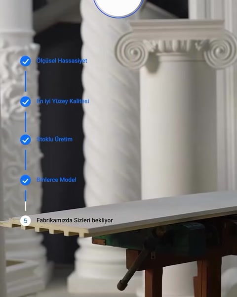 Beyaz panel, dekoratif sütunların önündeki tezgâhta duruyor
