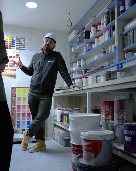 Kimyager laboratuvar raf dizisi önünde formül çalışmasını anlatıyor