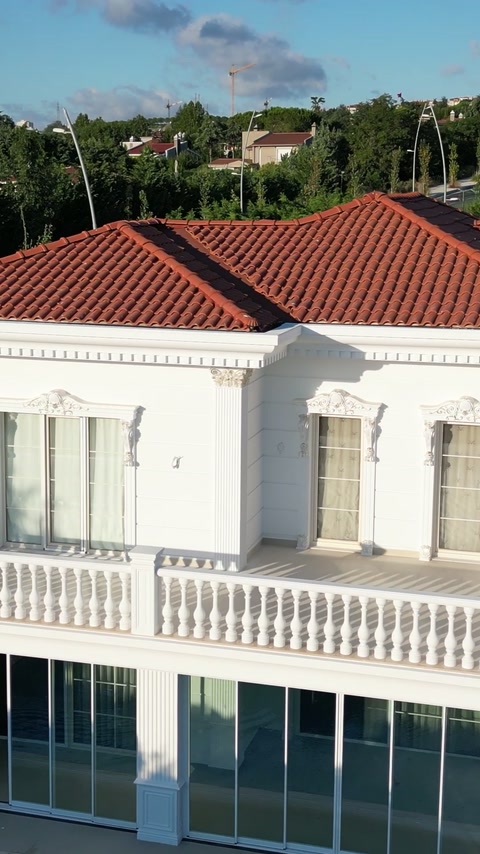 Balüstradlı balkon, söveler ve kornişlerle tamamlanan villa cephesi