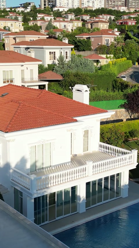 Kırmızı çatılı villanın beyaz silmelerle çevrelenmiş dış cephesi