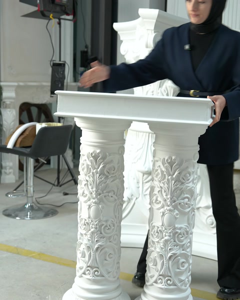 İki oyma desenli dekoratif sütun masa üzerinde sergileniyor