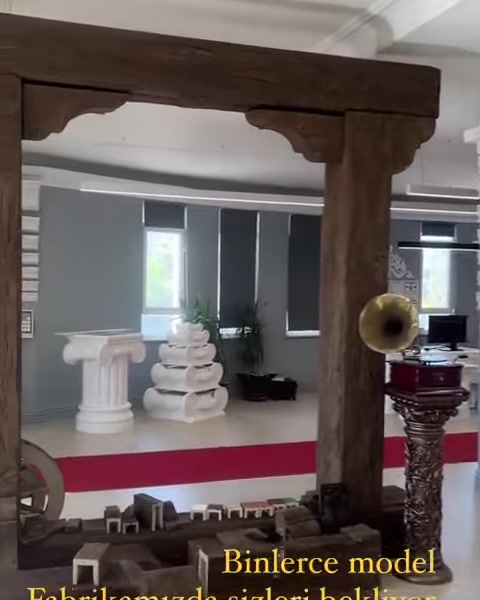 Ahşap görünümlü dekoratif kiriş sistemi showroom alanını çerçeveliyor.