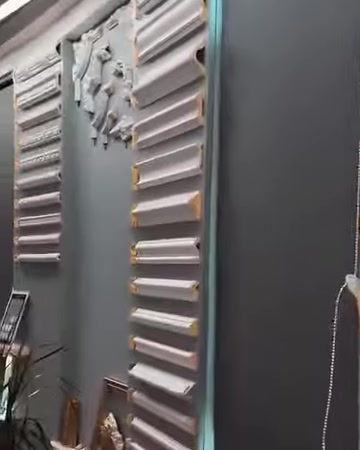 Düz kartonpiyer ve dekoratif motif seçenekleri showroom duvarında sergileniyor