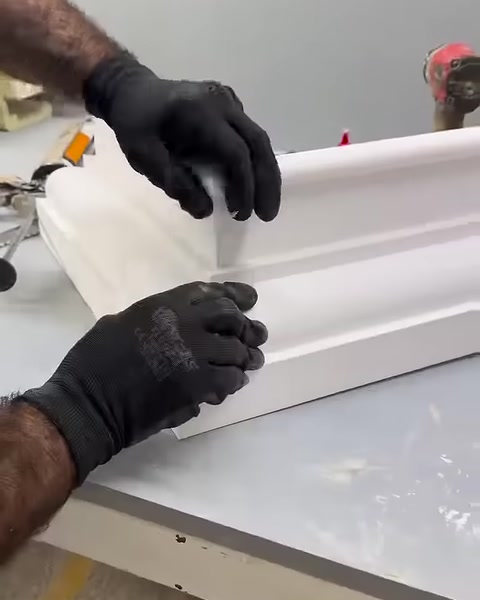Eldivenli usta açılı kesimleri birleştirerek köşeyi sıkıca oturtuyor.