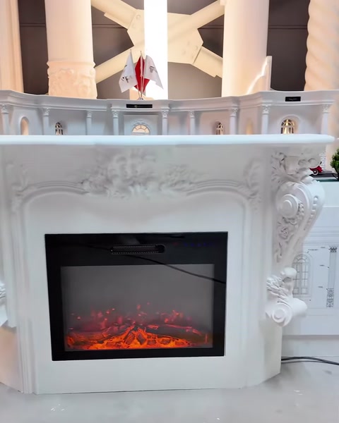 Kabartmalı beyaz şömine çerçevesi ve çalışan elektrikli iç hazne